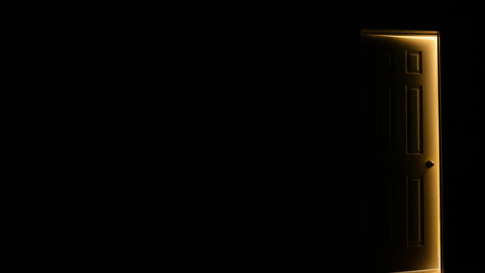An open door letting light into a dark room
