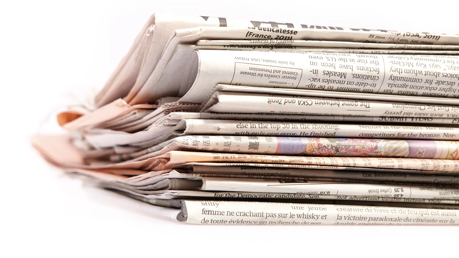 Una pila di quotidiani piegati su sfondo bianco